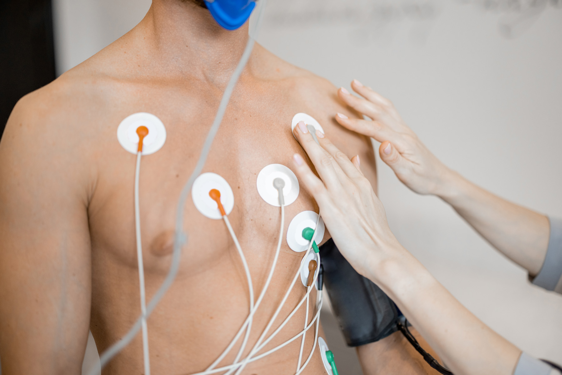 Torso of man athlete with electrodes, testing heart system on bike simulator